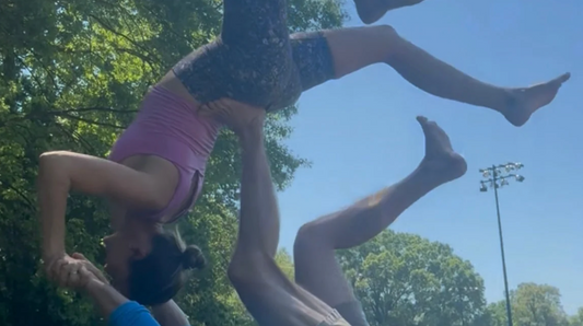 Outdoor acro yoga practice representing movement, strength, connection, and doing what fuels your fire