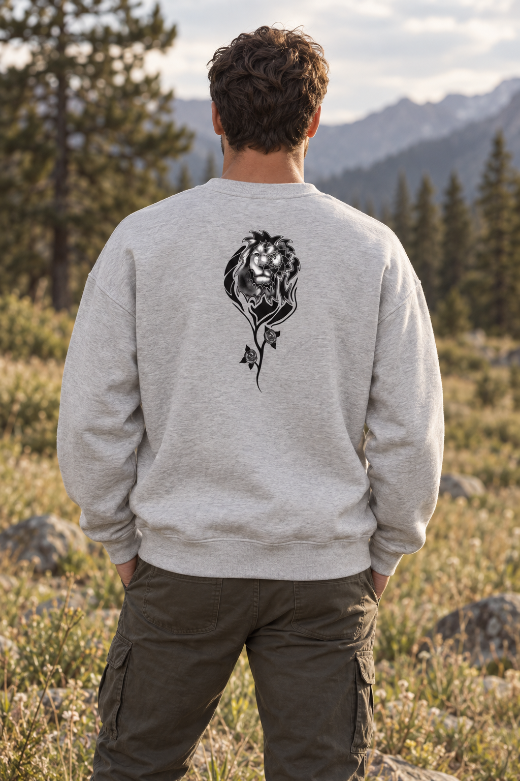 Man wearing black organic cotton sweatshirt with black and white pine forest and mountain artwork on the back