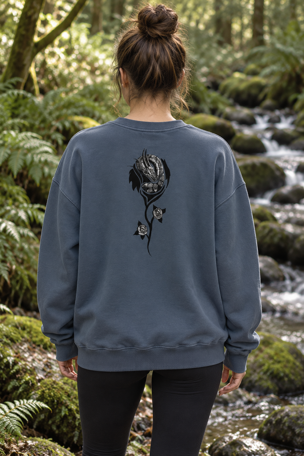 Woman wearing slate blue organic cotton sweatshirt with black dragon and floral artwork on the back